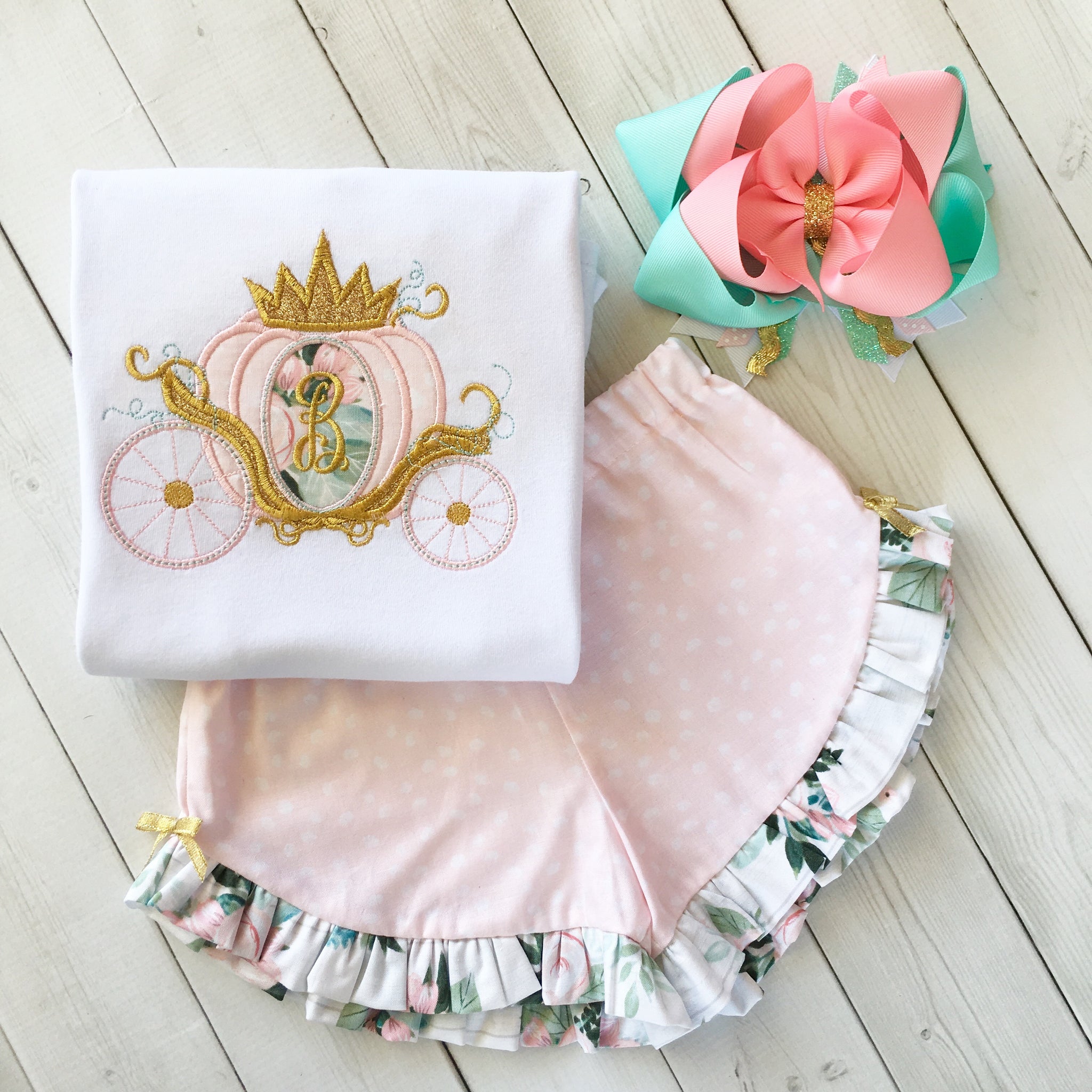 Gorgeous princess outfit for girls, toddlers and babies. Cinderella -like carriage done in pink petals, topped with gold glitter crown. Ruffled shorts are perfection in pink petal fabric finished with floral ruffles and gold bows.