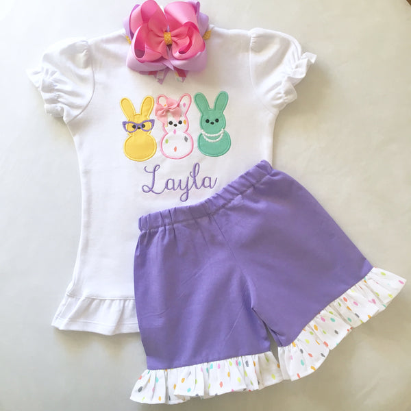 Girls easter outfit with shirt and ruffled shorts and easter bow. Shirt embroidered with three decorated bunnies inspired by Peeps! Lavender shorties finished with a confetti top ruffle.