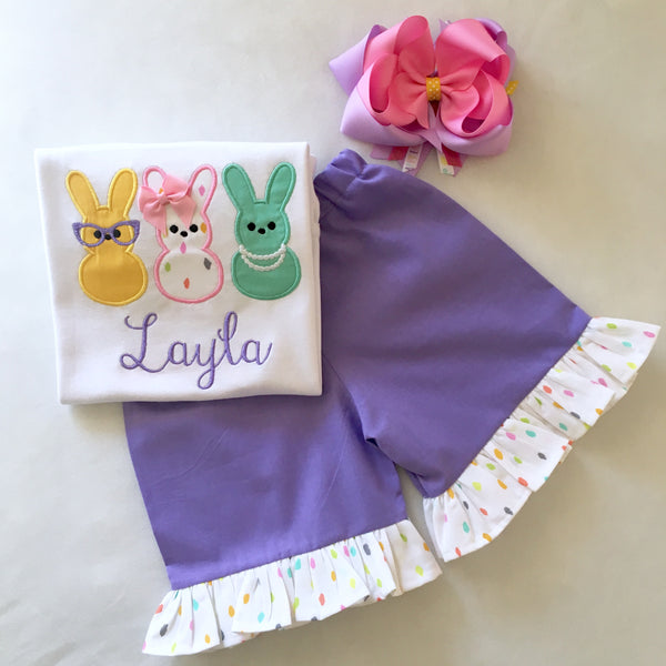 Girls easter outfit with shirt and ruffled shorts and easter bow. Shirt embroidered with three decorated bunnies inspired by Peeps! Lavender shorties finished with a confetti top ruffle.
