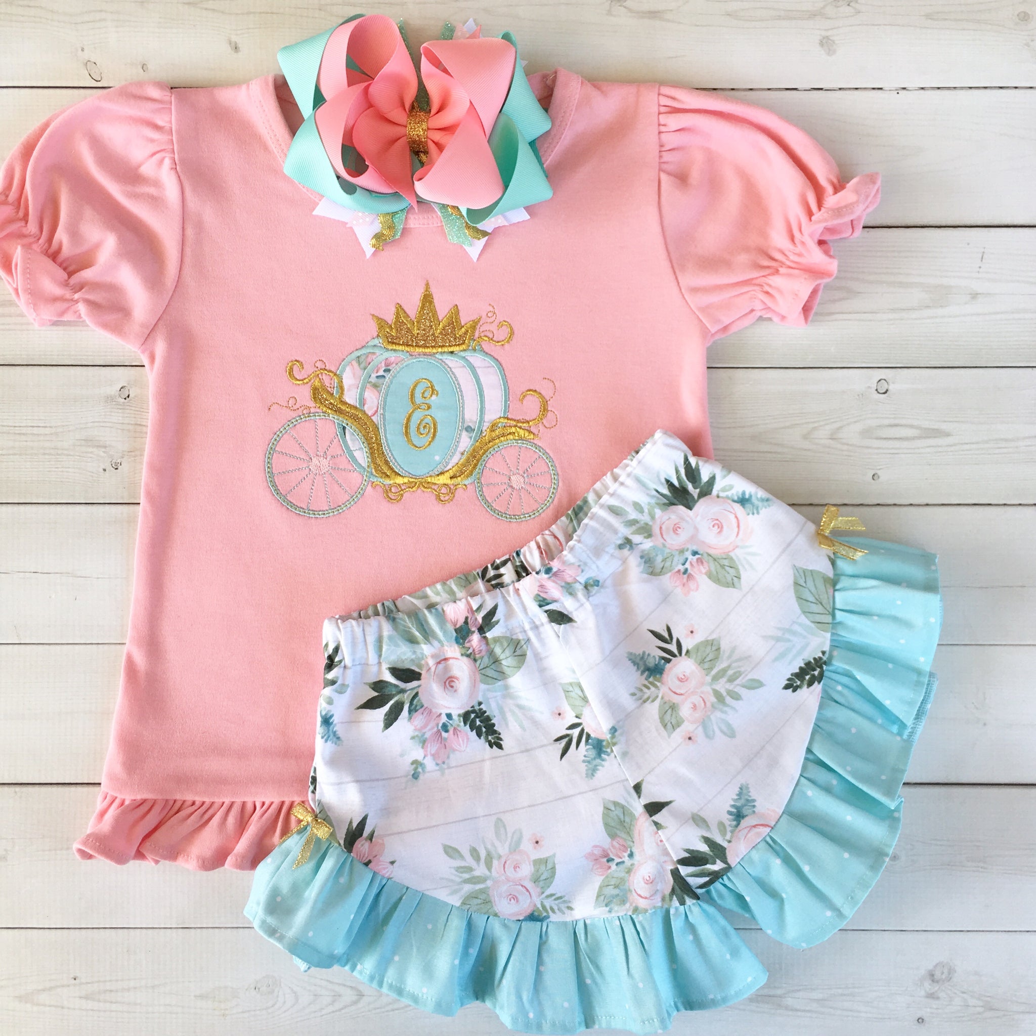 Gorgeous princess outfit for girls, toddlers and babies. Princess carriage topped with glitter crown customized with first initial. Floral ruffled shorts are perfection!